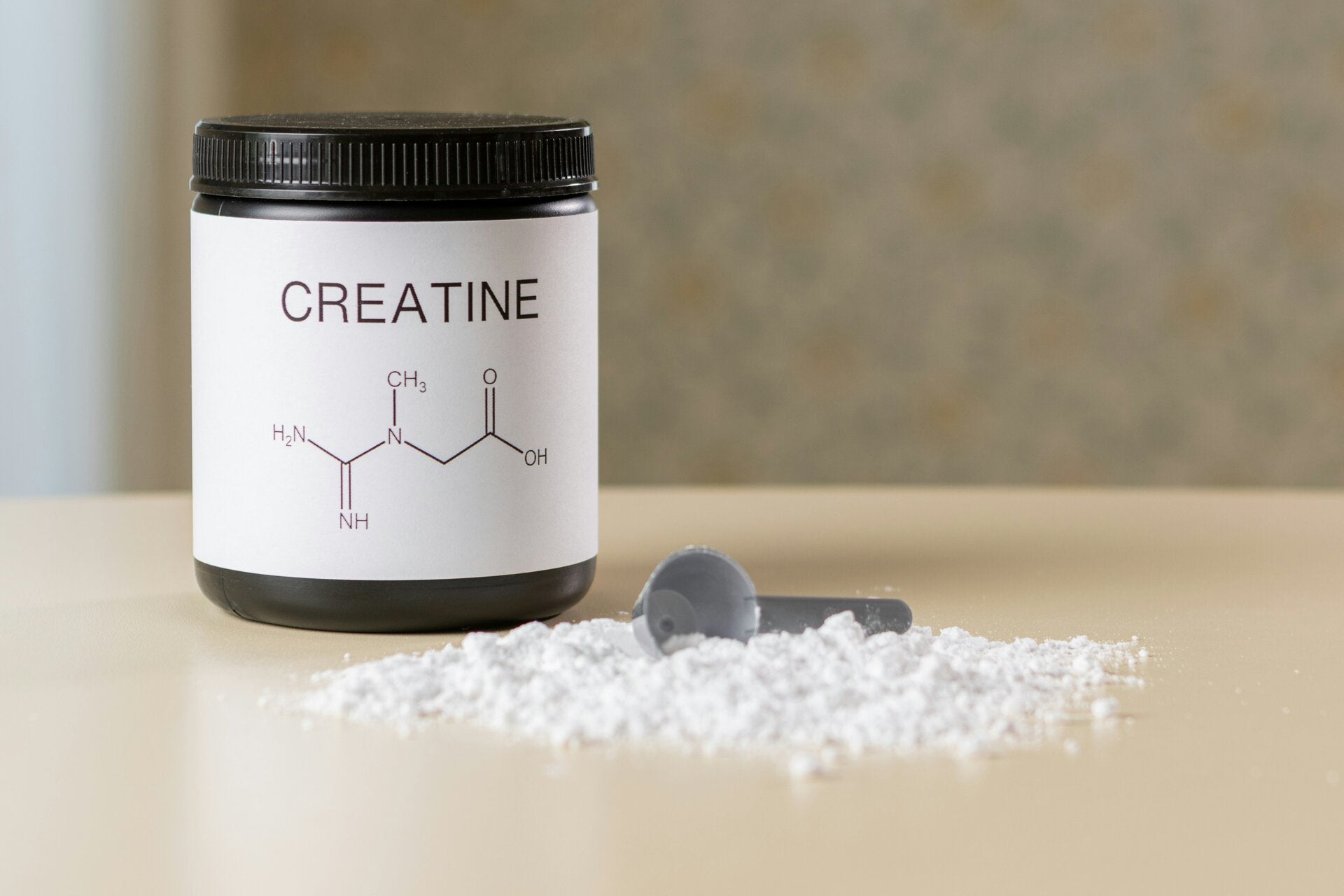 Creatine powder in a jar with chemical structure on label