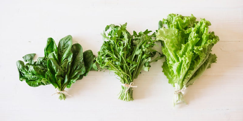 "A variety of fresh leafy greens, including spinach, arugula, and lettuce