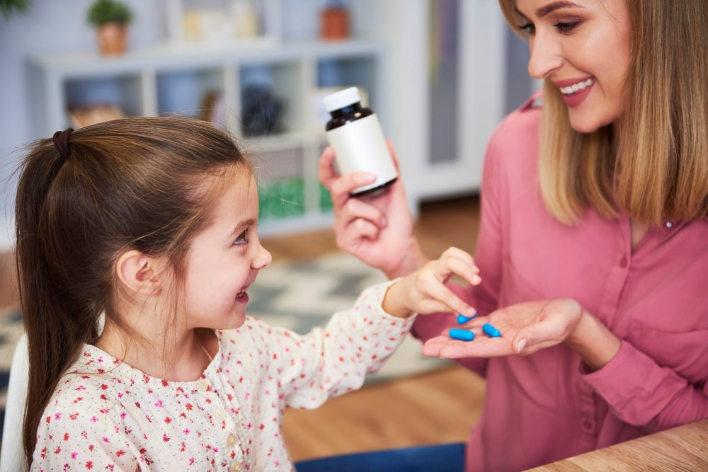 Mother offering vitamins to daughter, emphasizing Lion's Mane benefits for kids